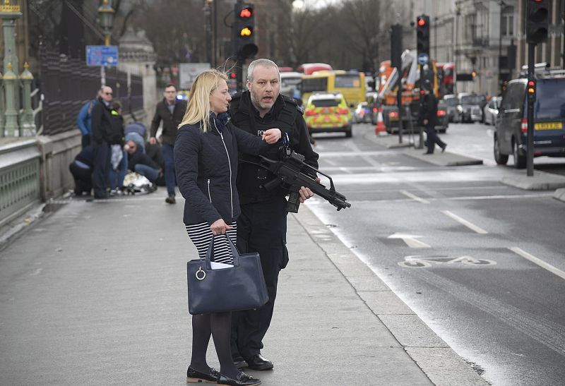 Un agente de policía ayuda a una mujer entre la confusión en el puente de Westminster