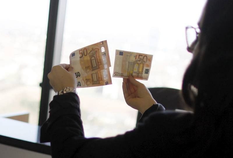 Una mujer observa dos billetes nuevos de 50 euros junto a uno de la serie original durante una presentación en Alemania. 