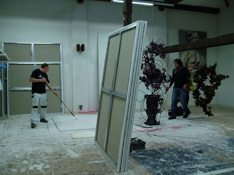 Uno de los ayudantes dando la primera capa al cuadro