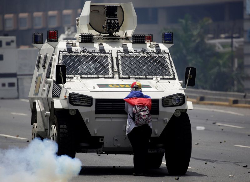 Una manifestante de la oposición bloquea una tanqueta de la Policía durante la manifestación contra Maduro en Caracas, Venezuela