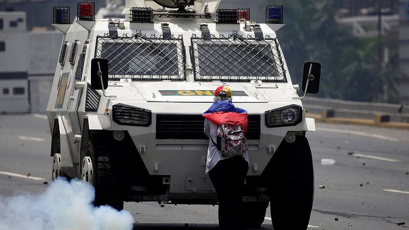 Una manifestante de la oposición bloquea una tanqueta de la Policía durante la manifestación contra Maduro en Caracas, Venezuela