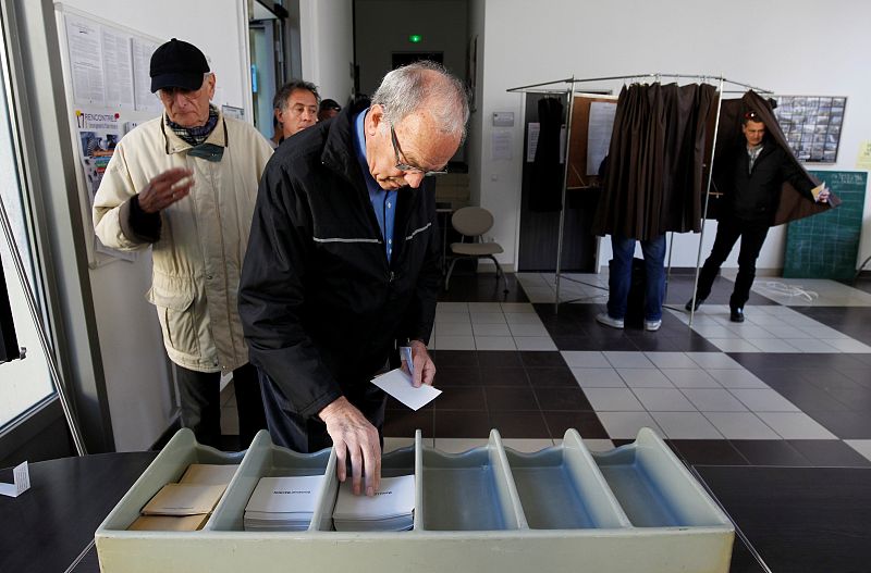Un hombre elige una papeleta en un colegio electoral en Marsella