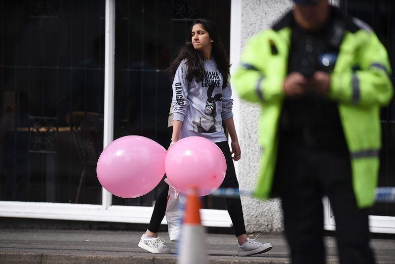 Una seguidora de Ariana Grande pasa junto al Manchester Arena tras el atentado