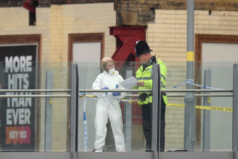 Un especialista forense y un agente de policía recogen pruebas en el vestíbulo que conecta el Manchester Arena con la Estación Victoria