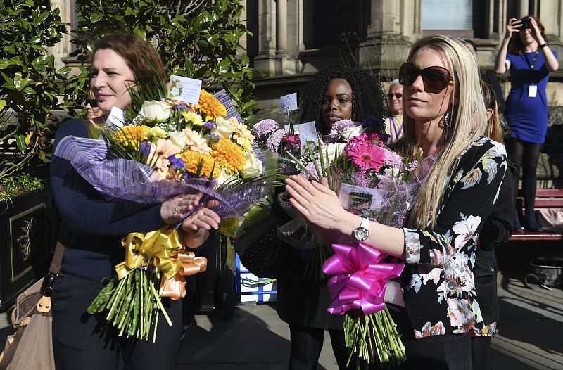 Varios de los asistentes al acto portan flores en recuerdo de los 22 fallecidos y casi 60 heridos en el atentado