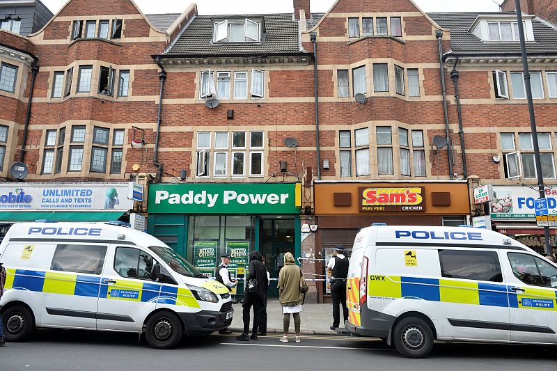 Agentes de policía permanecen frente a uno de los edificios donde se ha llevado a cabo un registro en Barking Road, Londres