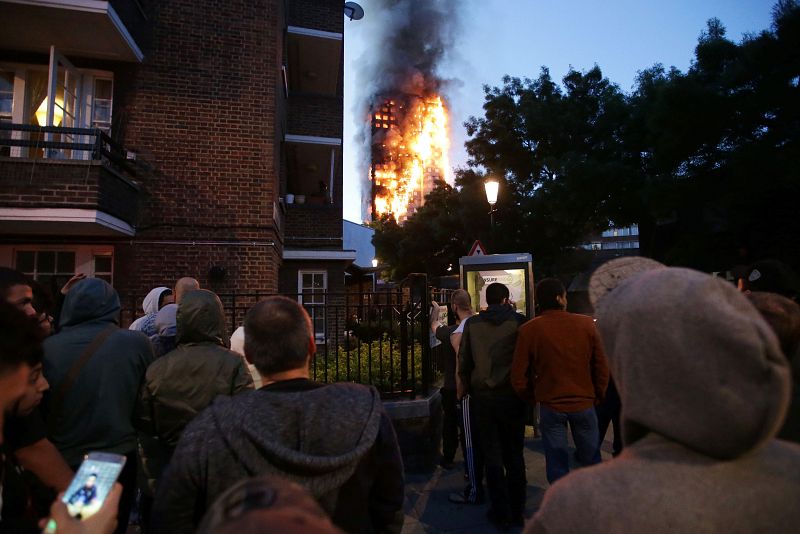 Vecinos del barrio miran mientras la Torre Grenfell arde.