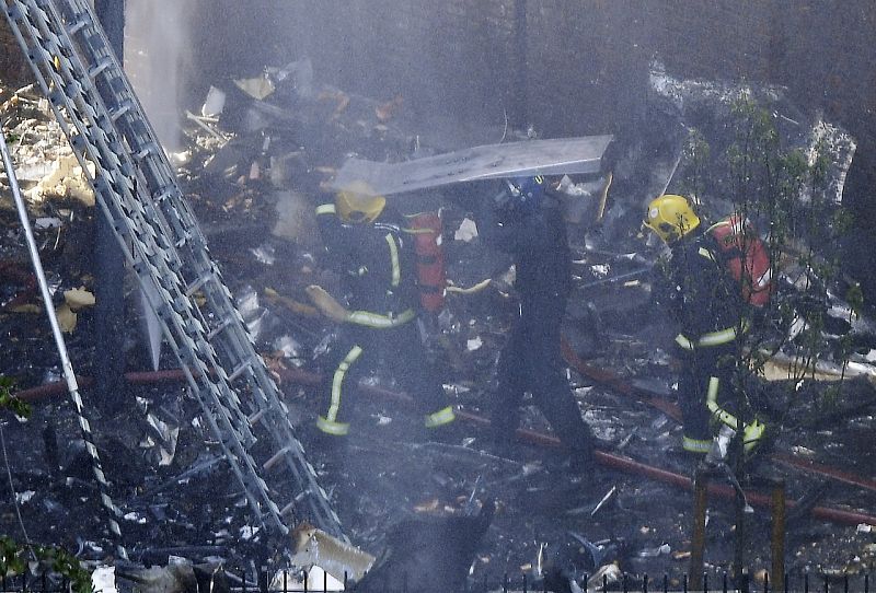 Miembros de los servicios de emergencias trabajan en los alrededores de la Torre Grenfell para extinguir el incendio.