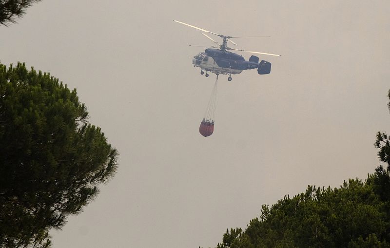 Vista de uno de los helicópteros que trabajan en la extinción. Los medios aéreos no han podido volar hasta que ha amanecido.