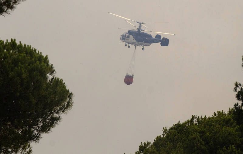 Vista de uno de los helicópteros que trabajan en la extinción. Los medios aéreos no han podido volar hasta que ha amanecido. 
