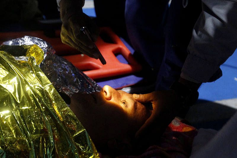 Médicos atienden a un buzo miembro del cuerpo de bomberos de Envigado después de realizar una inmersión en busca de supervivientes. 