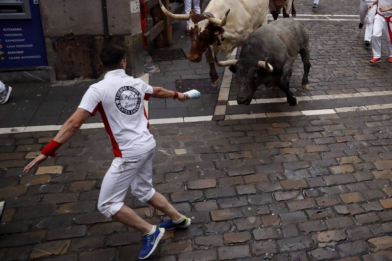 Un mozo corre ante el toro que se había quedado rezagado, en la curva de Mercaderes