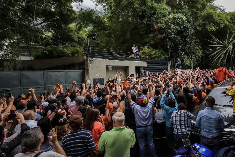 El opositor venezolano Leopoldo López saluda a seguidores desde dentro de su residencia en Caracas