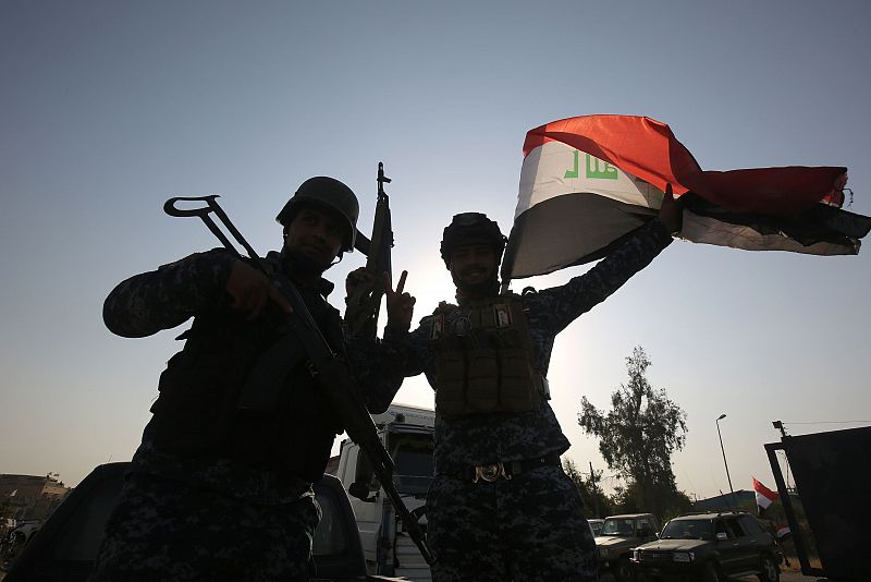 Varios soldados iraquíes celebran la reconquista de Mosul levantando una bandera
