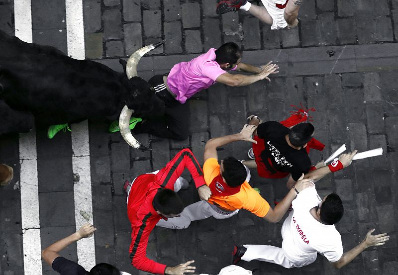 Un mozo cae atropellado por uno de los astados Uno de los toros de la ganadería madrileña de Victoriano del Río a su paso por la calle Estafeta de Pamplona en el sexto encierro de los Sanfermines 2017