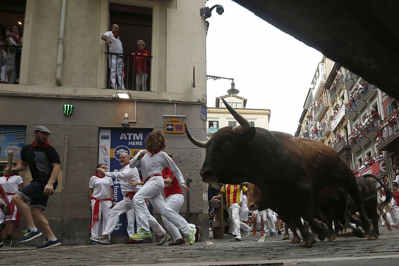 Los toros de la ganadería gaditana de Núñez del Cuvillo a su paso por la curva de Mercaderes en el séptimo encierro de Sanfermines 2017 que ha dejado dos heridos por asta de toro