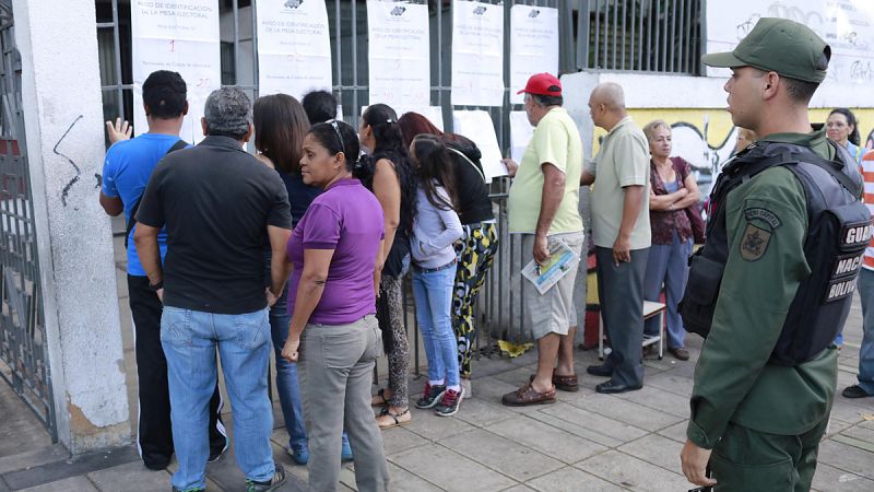 Los ciudadanos buscan sus nombres en las listas antes de votar en las elecciones.