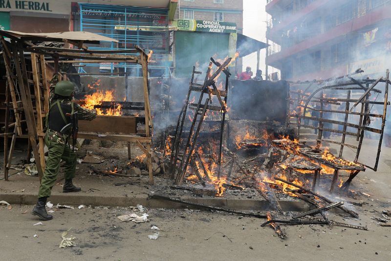 Un agente intenta apagar el incendio de un quiosco en Nairobi