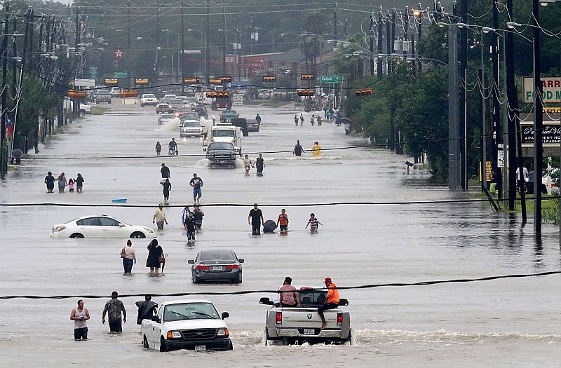 Varias personas en las calles inundadas de Houston.