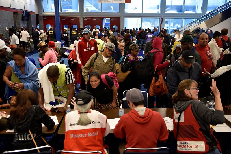 Voluntarios de la Cruz Roja registran a evacuados en el centro de convenciones George. R Brown de Houston.