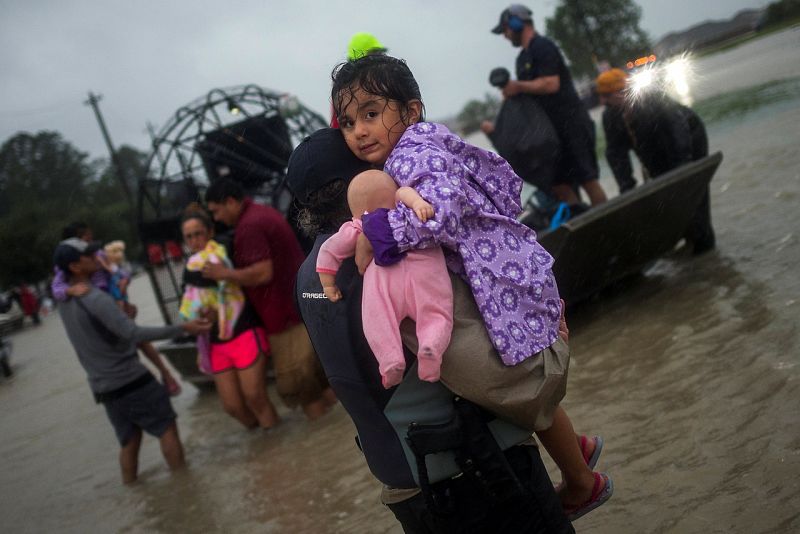 Una niña llega en bote con su familia a una zona elevada, huyendo de la inundación en Tidwell Road, este de Houston.