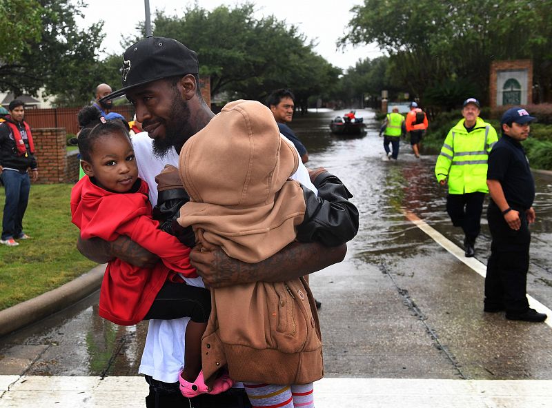 Un padre es evacuado junto a sus dos hijos en el distrito de Clodine, un suburbio de Houston