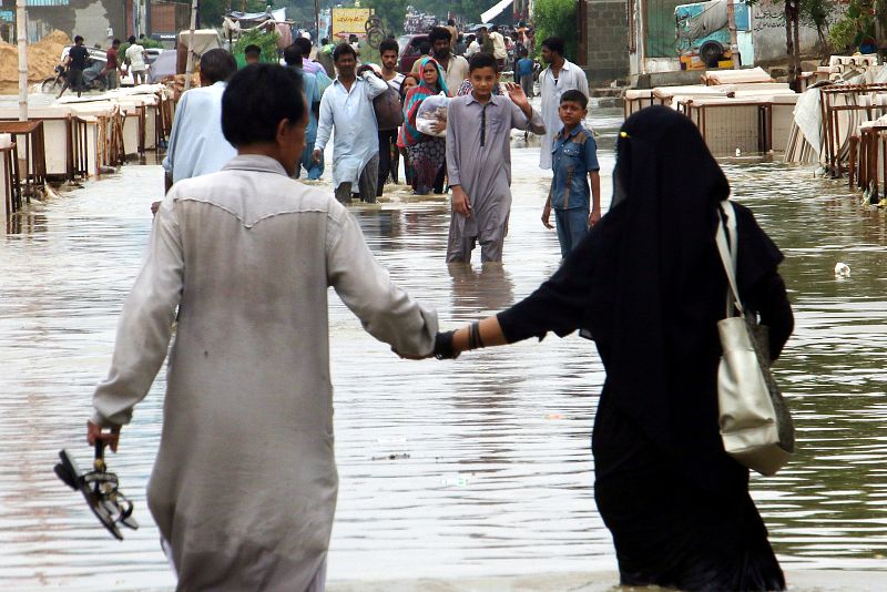 Varios ciudadanos se abren paso por las calles de Karachi
