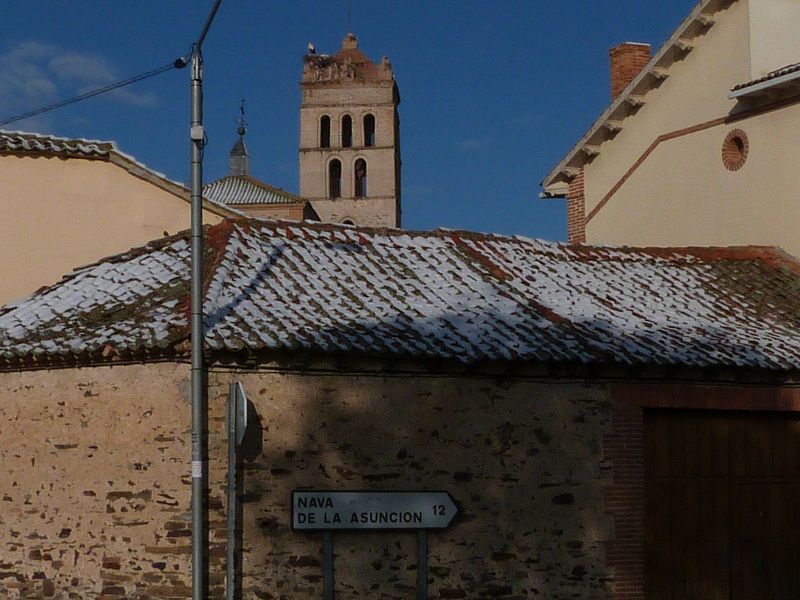 Tejados nevados en abril con la cigüeñas de fondo