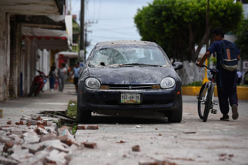 Un ciclista pasa junto a un vehículo averiado en el municipio de Matías Romero, en el estado mexicano de Oaxaca.