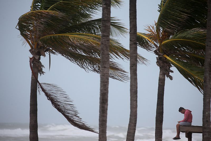 Un hombre, sentado junto al mar en la playa de Hollywood, Florida.