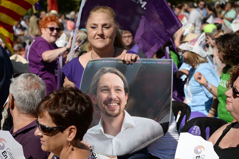 Una mujer sostiene una fotografía del líder de Podemos, Pablo Iglesias, durante los actos de celebración.