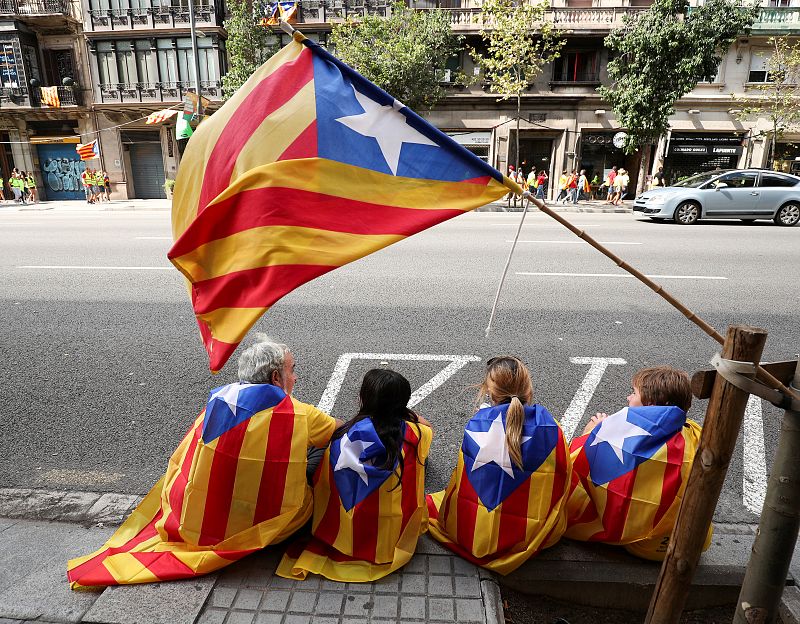 Un grupo de personas porta Esteladas antes de la manifestación de Barcelona en apoyo al referéndum del 1-O, con motivo de la Diada.