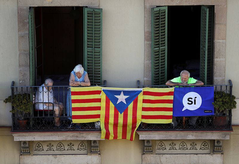 People watch from a balcony as thousands of people gather for a rally on Catalonia's national day 'La Diada' in Barcelona