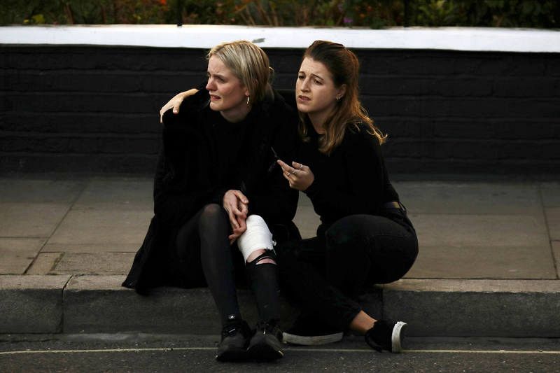 An injured woman reacts outside Parsons Green tube station in London