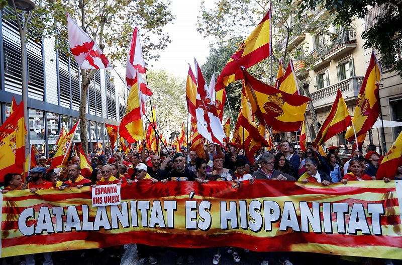 La gente camina detrás de una gran pancarta con la frase "catalanidad es hispanidad"