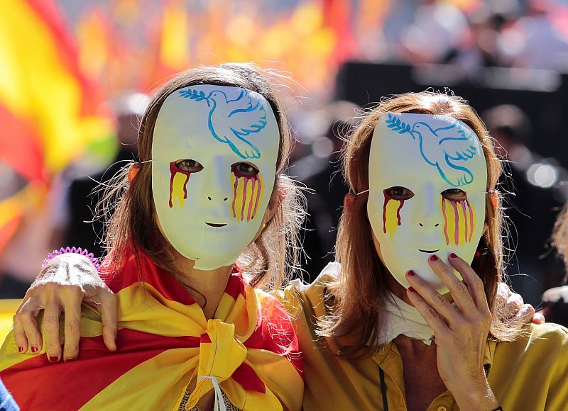 Dos mujeres con máscaras durante la marcha en defensa de la unidad de España