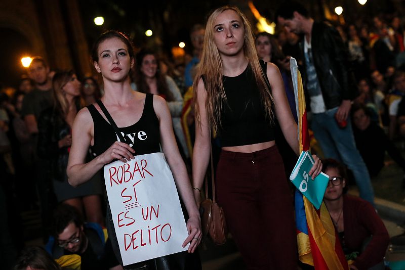 Las jóvenes sujetan un cartel durante las palabras del President a las afueras del Parlament