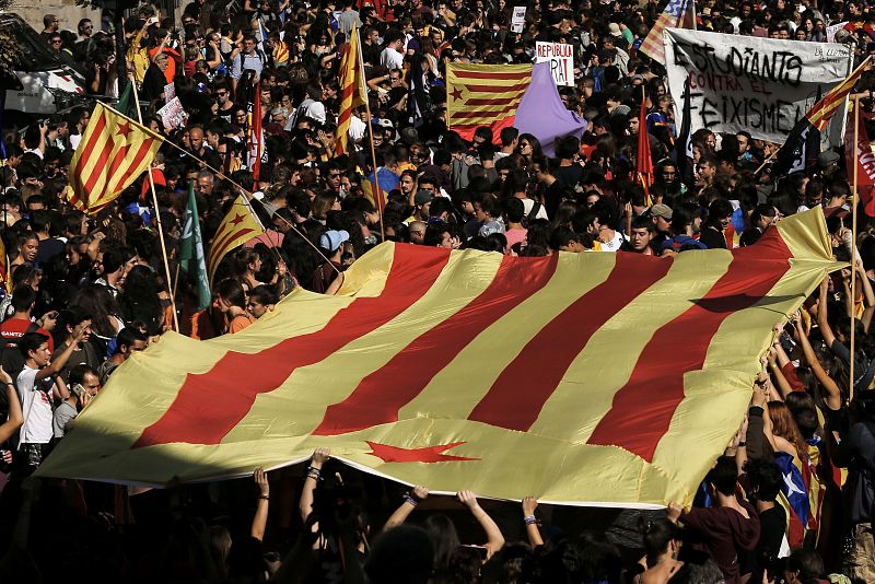 Los estudiantes llevan una gran bandera estelada ante al Palau de la Generalitat