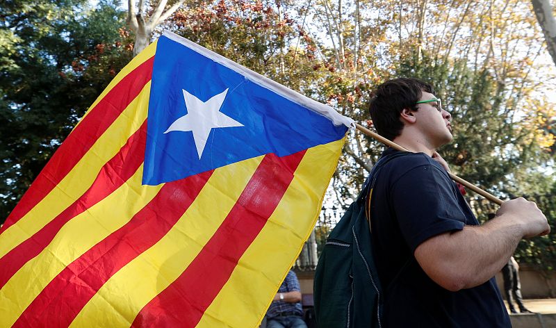 A demonstrator carries a Catalan separatist flag  outside the Catalan regional parliament in Barcelona
