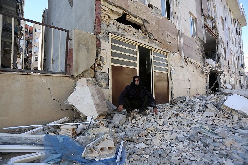 Un hombre fuera de un edificio dañado en la ciudad de Sarpul Zahab, en la provincia iraní de Kermanshah