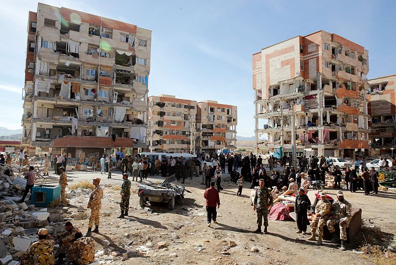 Víctimas del terremoto permanecen junto a edificios dañados en la ciudad iraní de Sarpul Zahab
