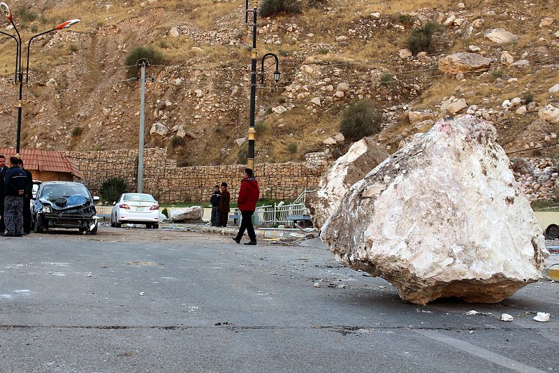 Un hombre pasa junto a una roca caída tras el terremoto en Darbandiján, cerca de la ciudad iraquí de Solimania