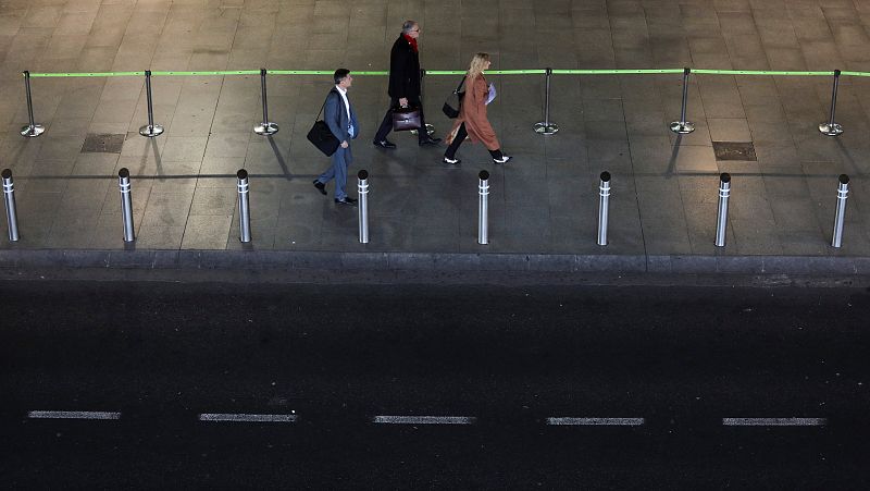 Viajeros recién llegados al Aeropuertp Madrid-Barajas Adolfo Suárez caminan por la parada de taxis vacía de la terminal