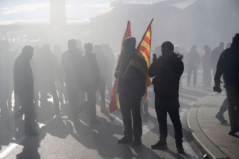 Un joven taxista sujeta dos banderas, una de España y otra de Cataluña, durante la manifestación en Madrid