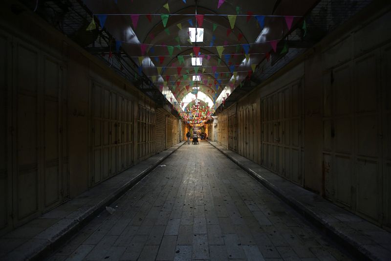 Palestinos pasean por un bazar vacío y cerrado por la huelga en Nablús