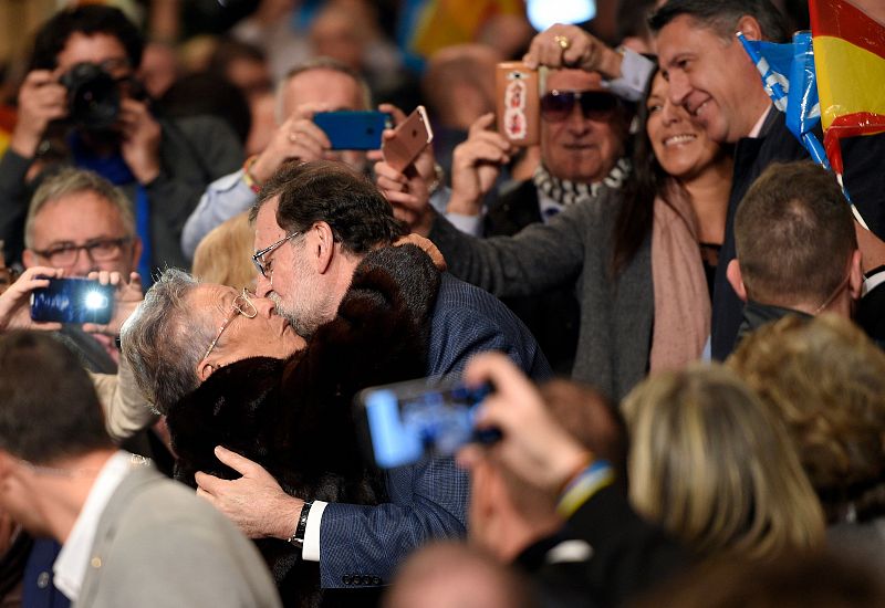 Rajoy, que ha tenido una alta participación en la campaña electoral, besa a una admiradora en un mitin en Salou.