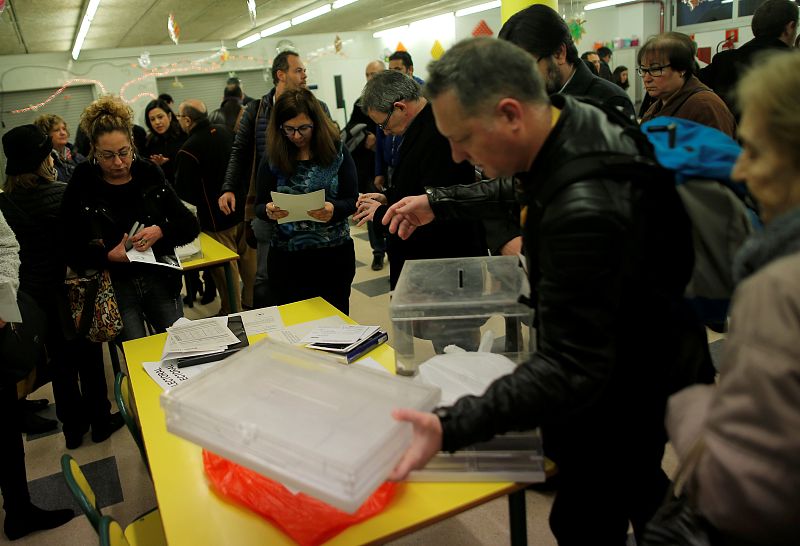 Electoral workers and representatives of political parties prepare a polling station for Catalonia's regional elections in Barcelona