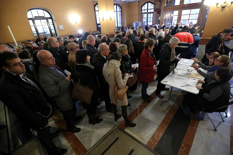 People wait to vote in Catalonia's regional elections at a polling station in Barcelona