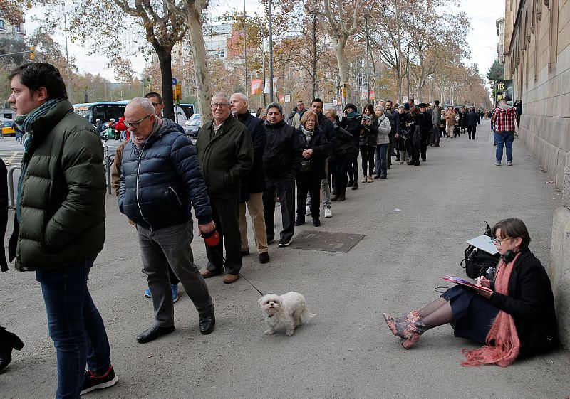 People queue to vote in Catalonia's regional elections at a polling station in Barcelona