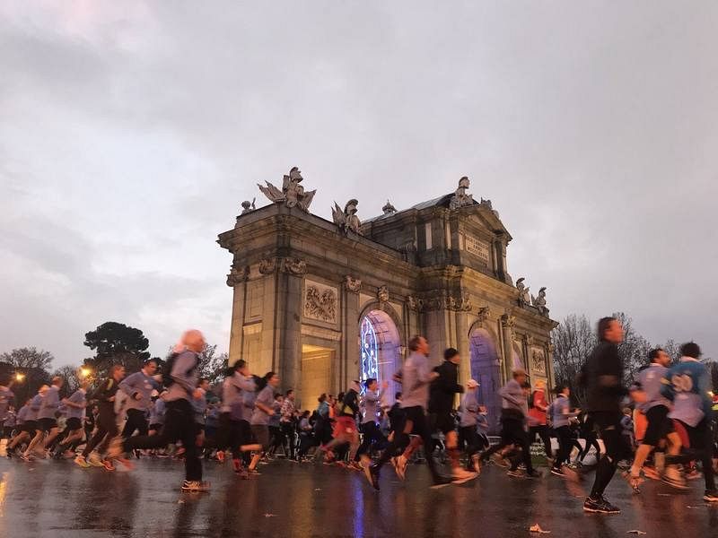 Los corredores de la carrera popular atraviesan la Puerta de alcalá durante la San Silvestre Vallecana 2017.